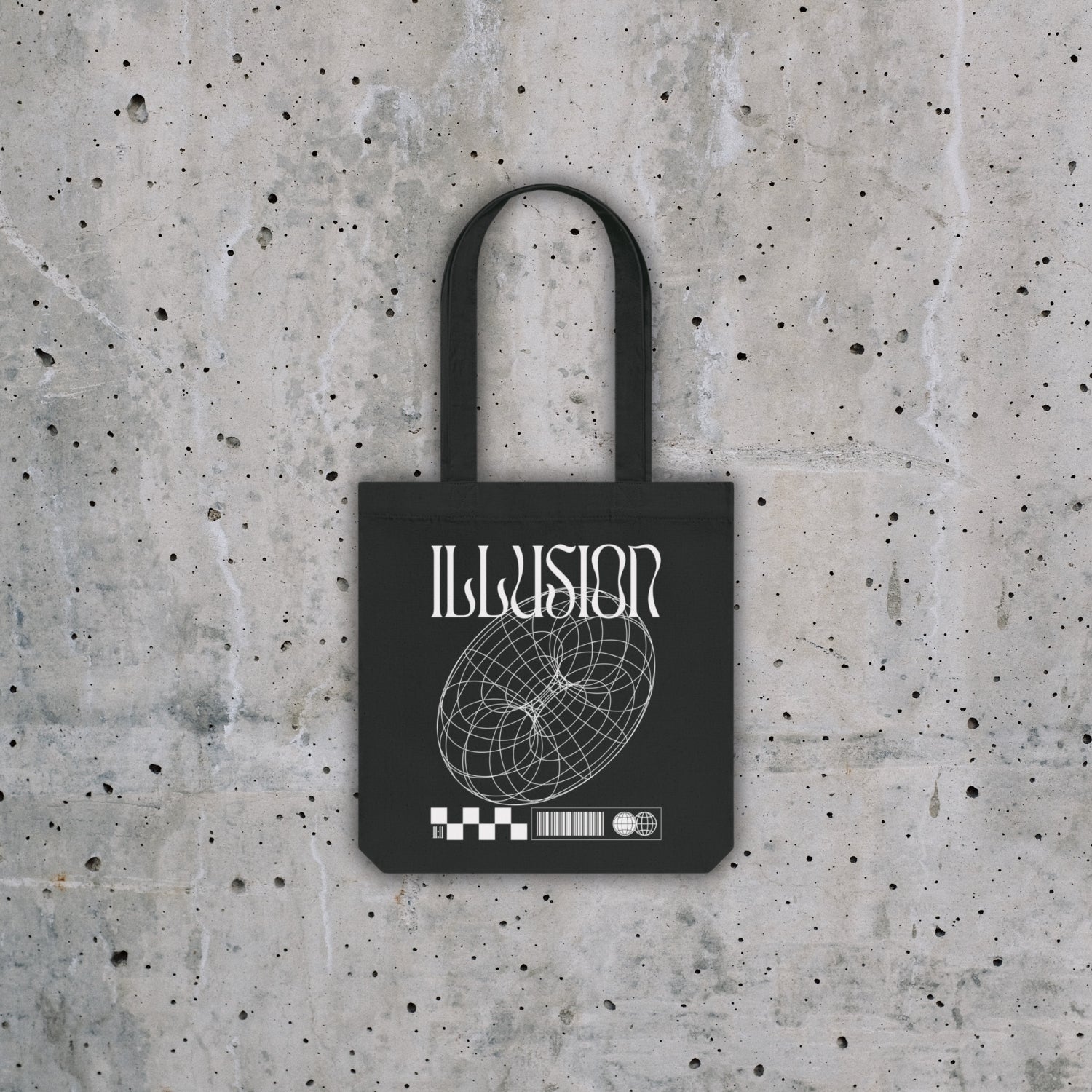 Totebag noir avec dessins blanc "Illusion" posé sur un fond effet béton.